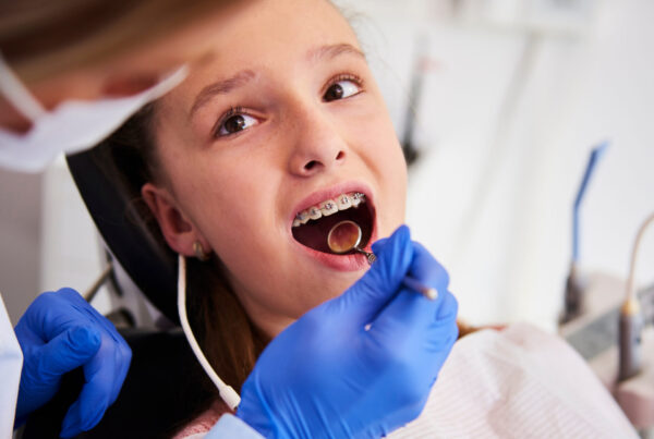 Part of orthodontist examining child's teeth in dentist's office