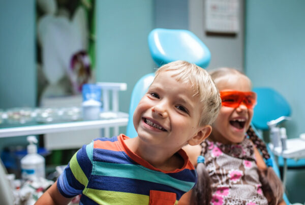 Two kids having fun and wearing medical eyeglasses during their visit to dentist office, the two are not scared. Healthy teeth and painless treatment, pediatric dentistry concept
